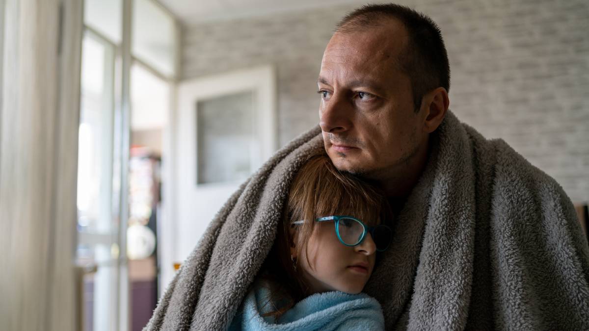 Father and daughter wrapped in blanket